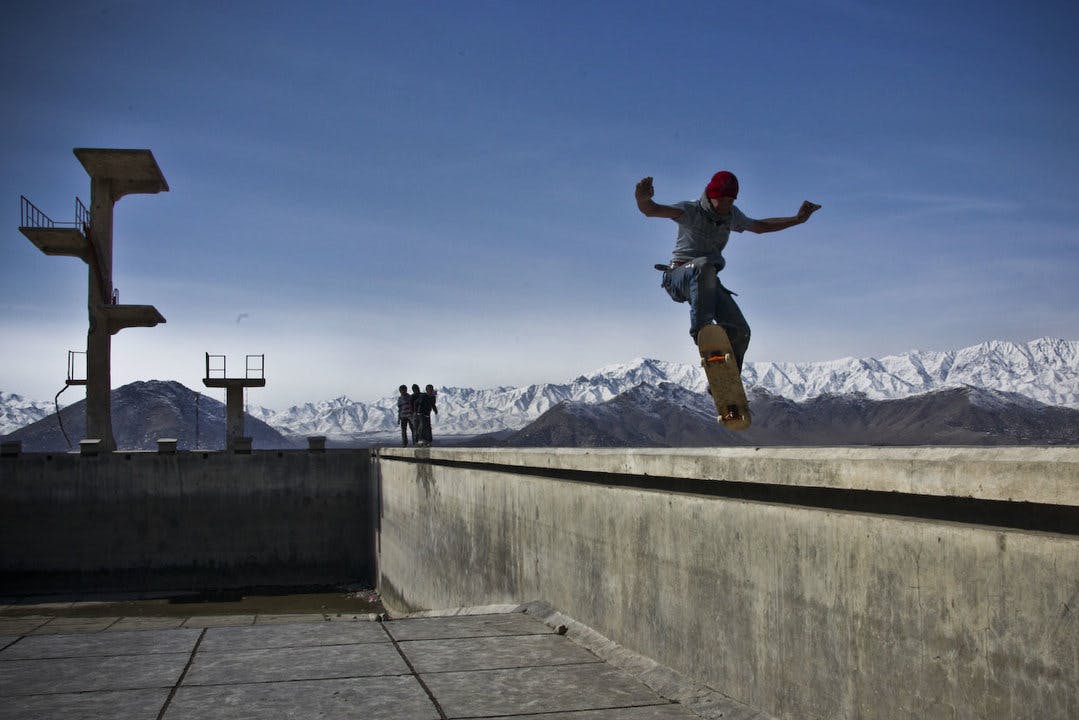 Children skating in an abandoned swimming pool in Afganistan