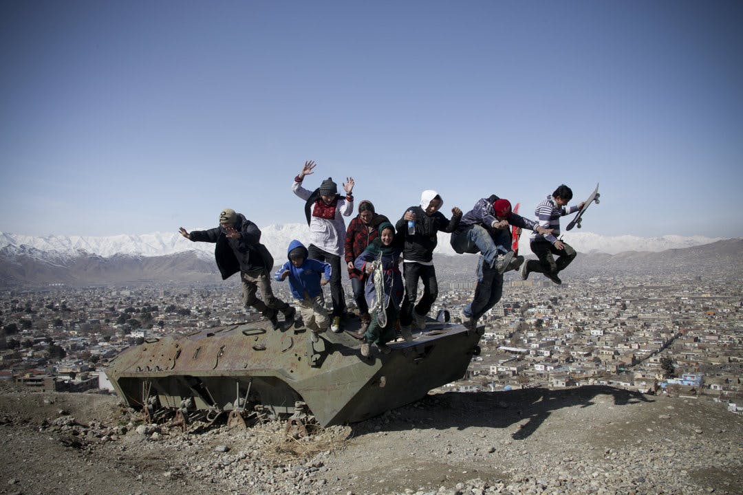 Skatistan Children skateing and jumping of an old destroyed tank